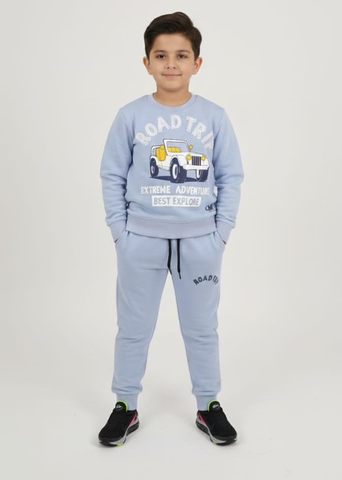 Child wearing a light blue tracksuit with a graphic design on a white background