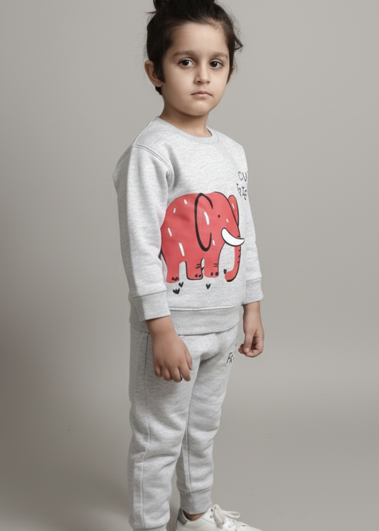 Child wearing a white sweatshirt with a red elephant design and gray pants on a plain background