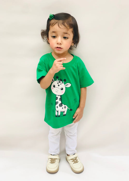 Child wearing a green t-shirt with a giraffe design on a white background