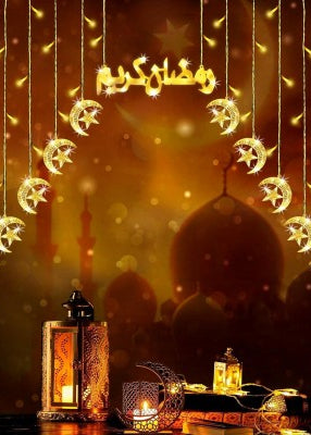 Decorative setup with hanging lights, lanterns, and a blurred mosque silhouette on a warm background.