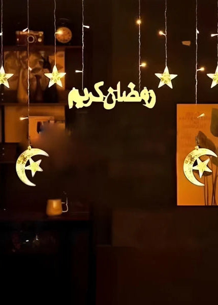 Decorative lights with moon and star shapes and Arabic text in a dark room.
