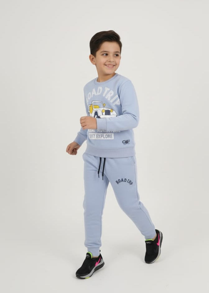 Child wearing a light blue 'Road Trip' themed outfit with a vehicle graphic.