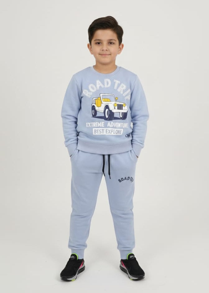 Child wearing a light blue tracksuit with a graphic design on a white background