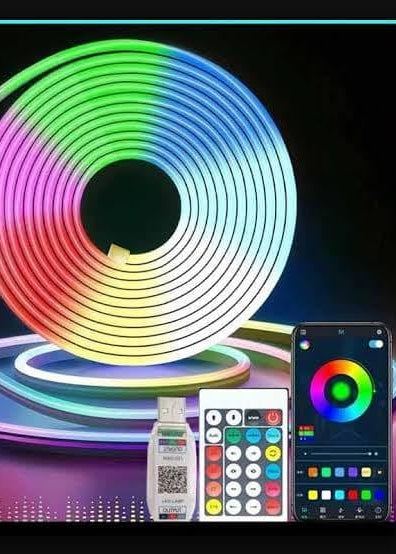 Roll of RGB LED strip light with remote control and smartphone app on a dark background