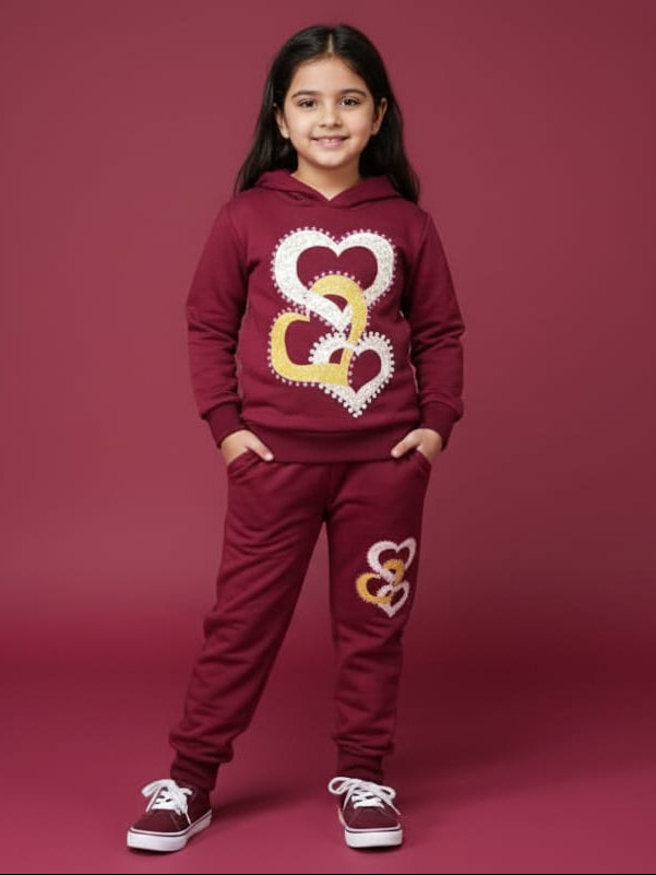 Girl wearing a maroon hoodie and pants with heart designs on a red background