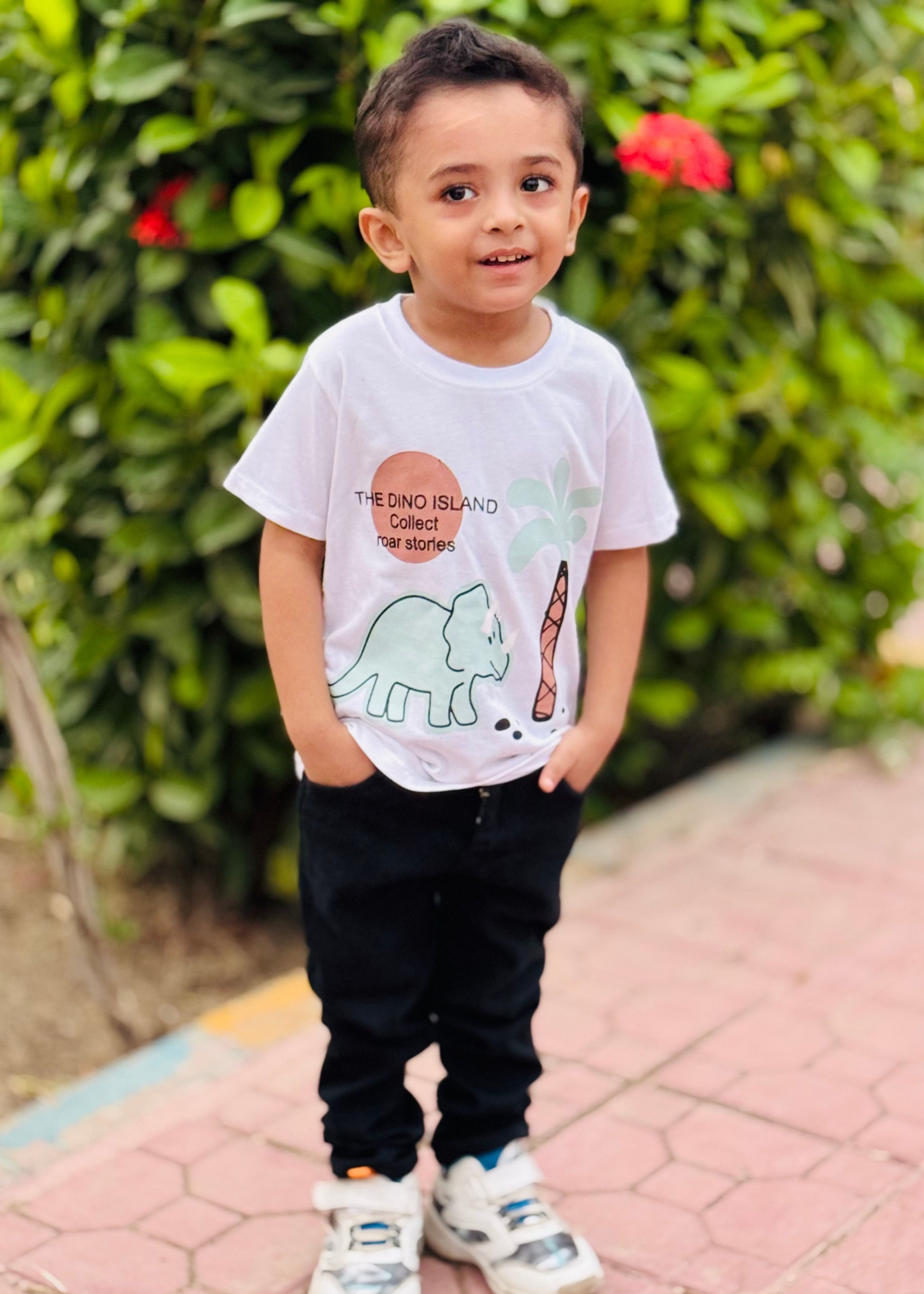 Child wearing a white t-shirt with a dinosaur graphic outdoors