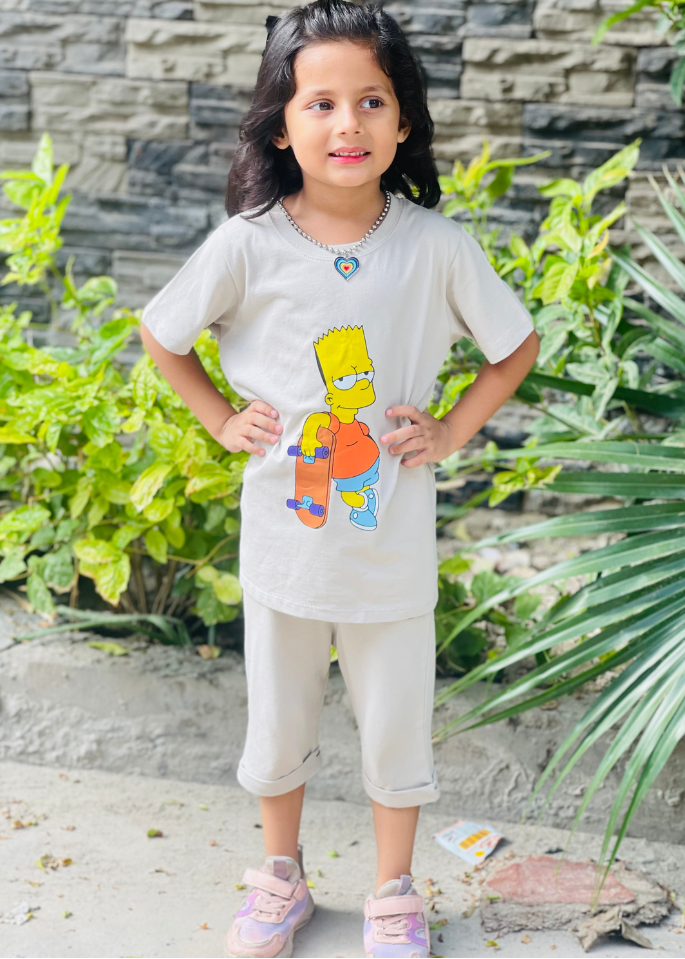 Child wearing a white t-shirt with a colorful graphic design outdoors.