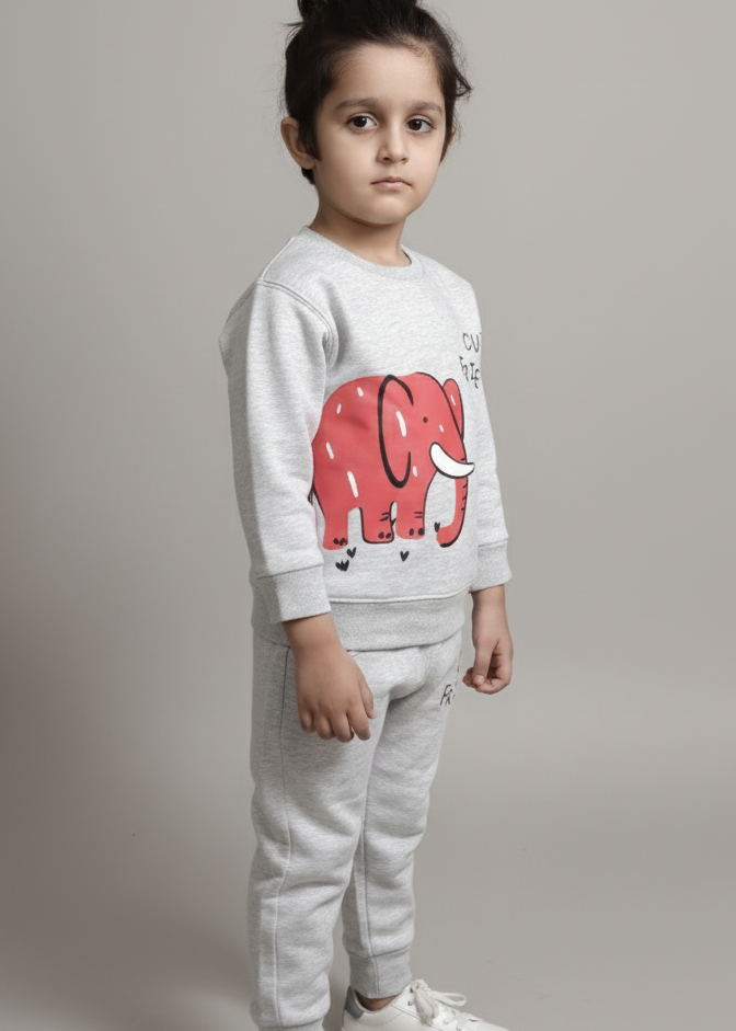 Child wearing a white sweatshirt with a red elephant design and gray pants on a plain background