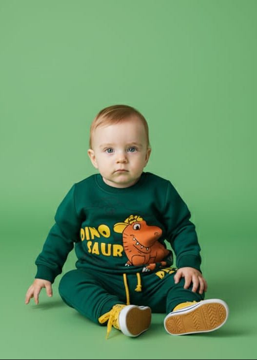 Child wearing a green dinosaur-themed outfit on a green background