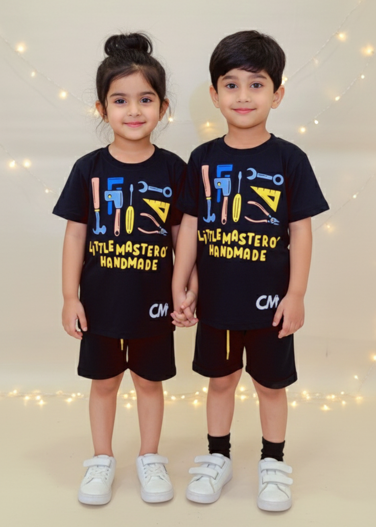 Two children wearing matching black t-shirts with colorful text and graphics on a light background.