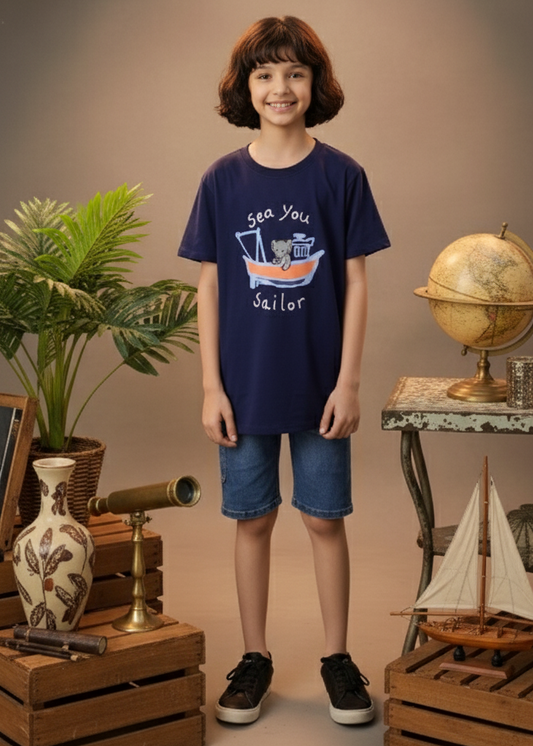 Child wearing a navy blue t-shirt with a graphic design, standing in a room with decorative items.