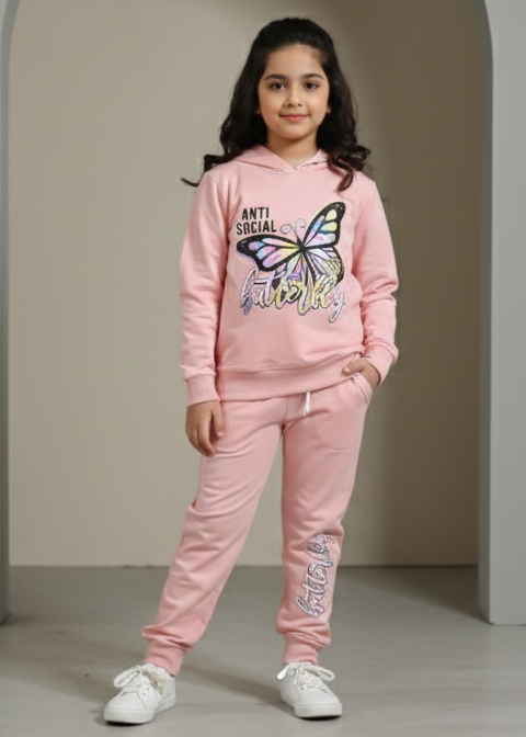 Young girl wearing a pink outfit with a butterfly design in a neutral setting