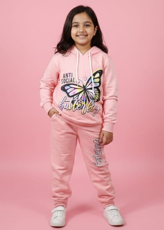 Child wearing a pink hoodie and pants with a butterfly design on a pink background