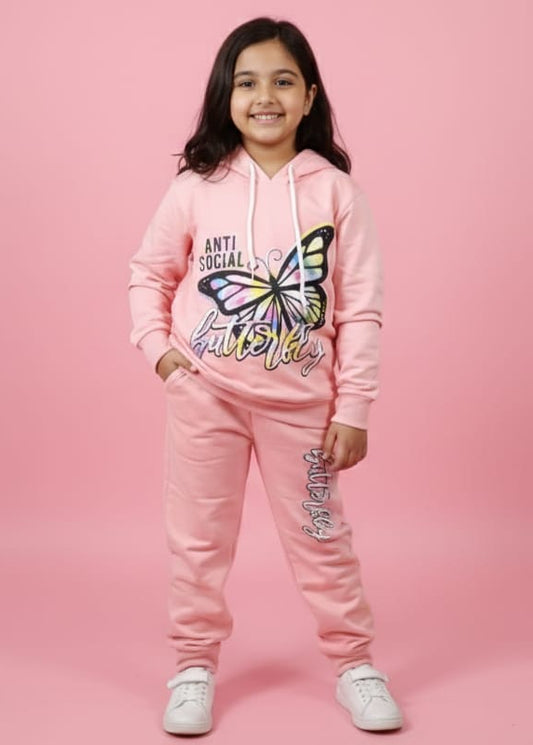 Child wearing a pink hoodie and pants with a butterfly design on a pink background