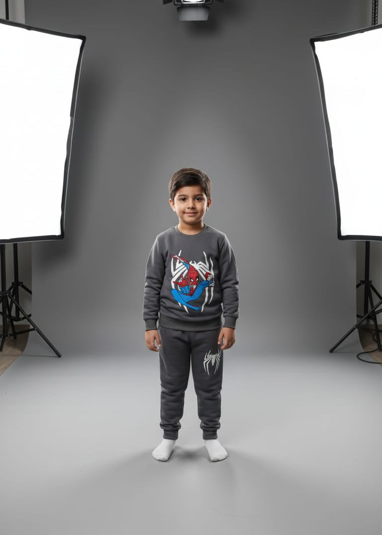 Child wearing a Spider-Man themed gray outfit in a photo studio setting with lighting equipment.