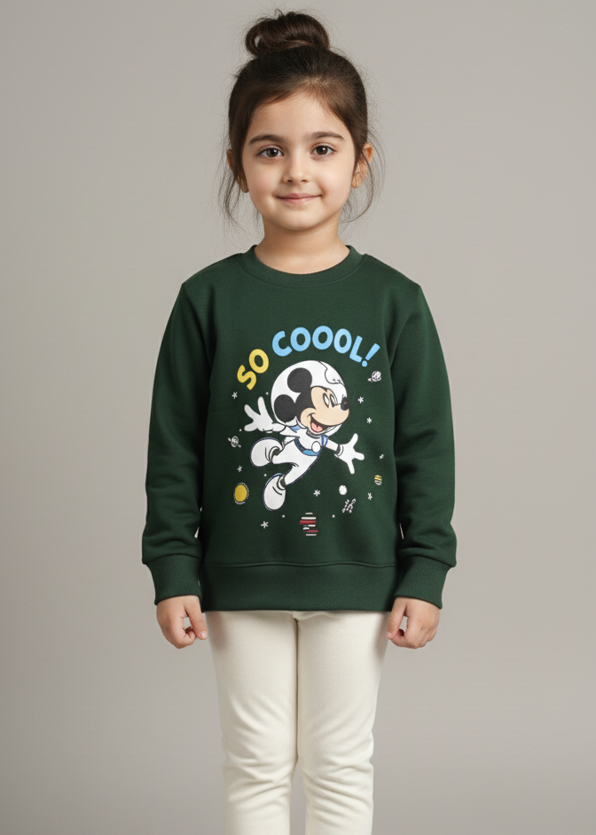 Child wearing a green sweatshirt with a graphic design on a gray background